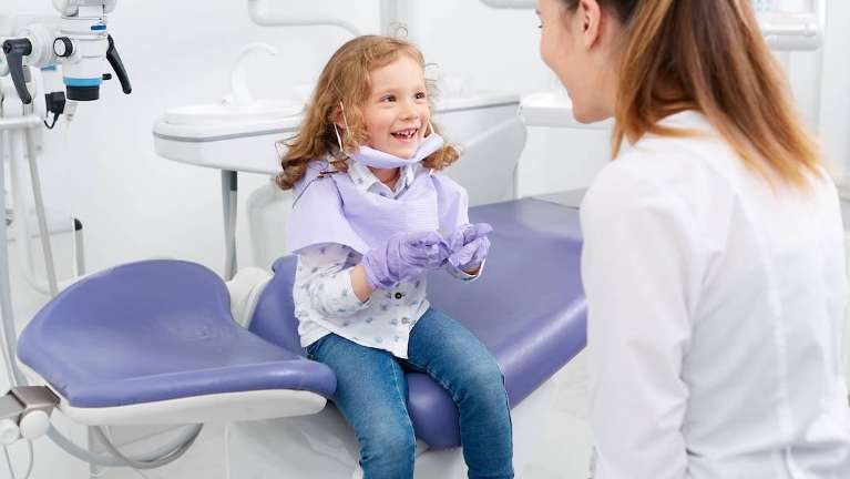 A child smiling at her dentist