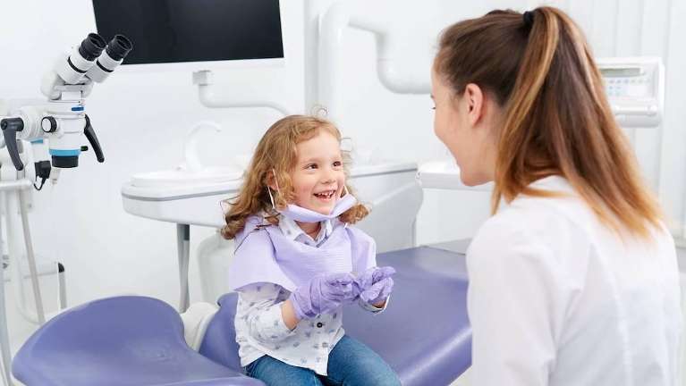 Girl smiling at dentist in dental office, palos heights il