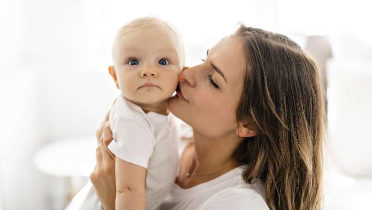 A woman kissing her baby | dentist palos heights