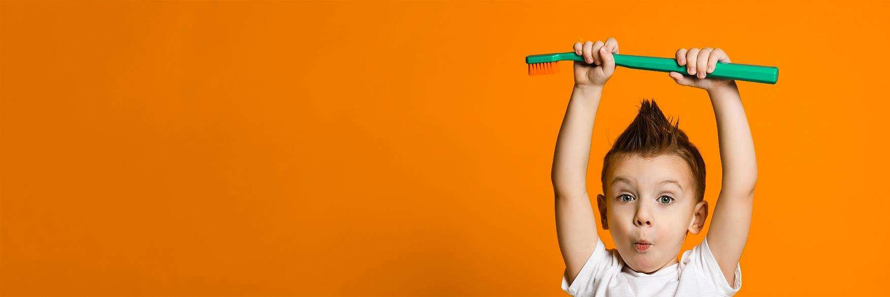 Child holding a toothbrush | Kids Dentist Palos Heights